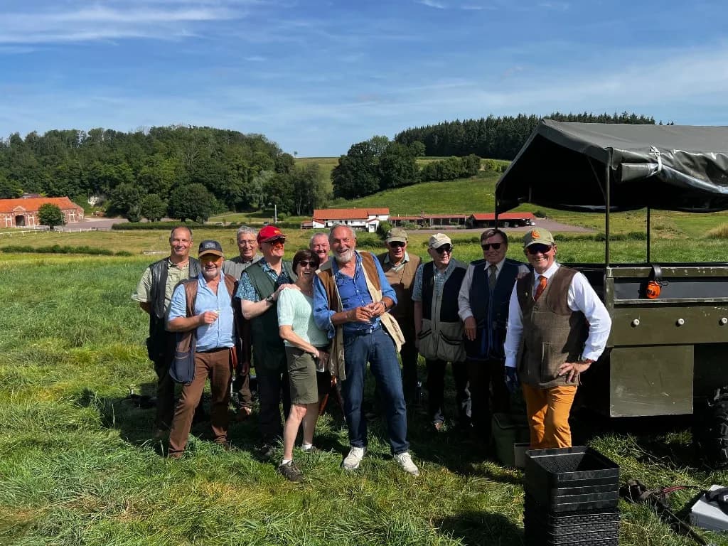 Photo de groupe des tireurs sur le terrain de battue simulée, près du Land Rover, au Domaine de La Planquette