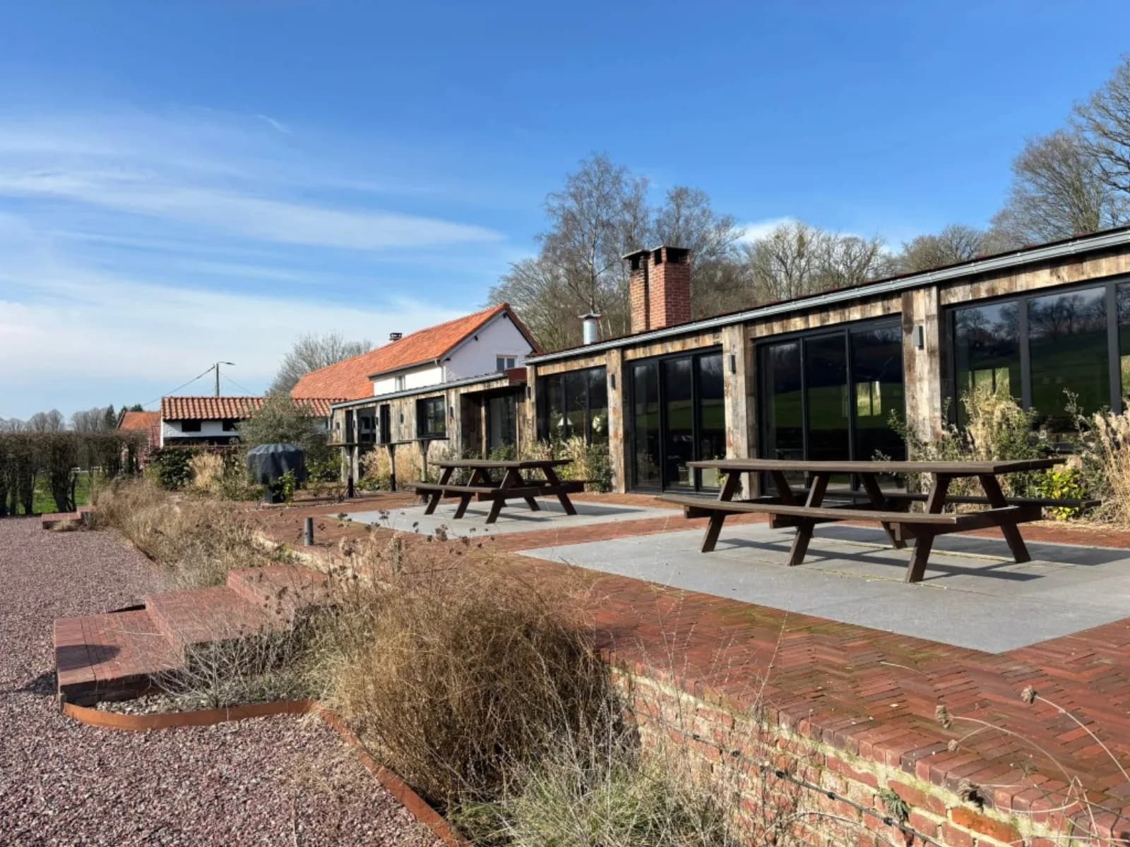 Les extérieurs — bâtiment en bois, terrasse et prairie du domaine