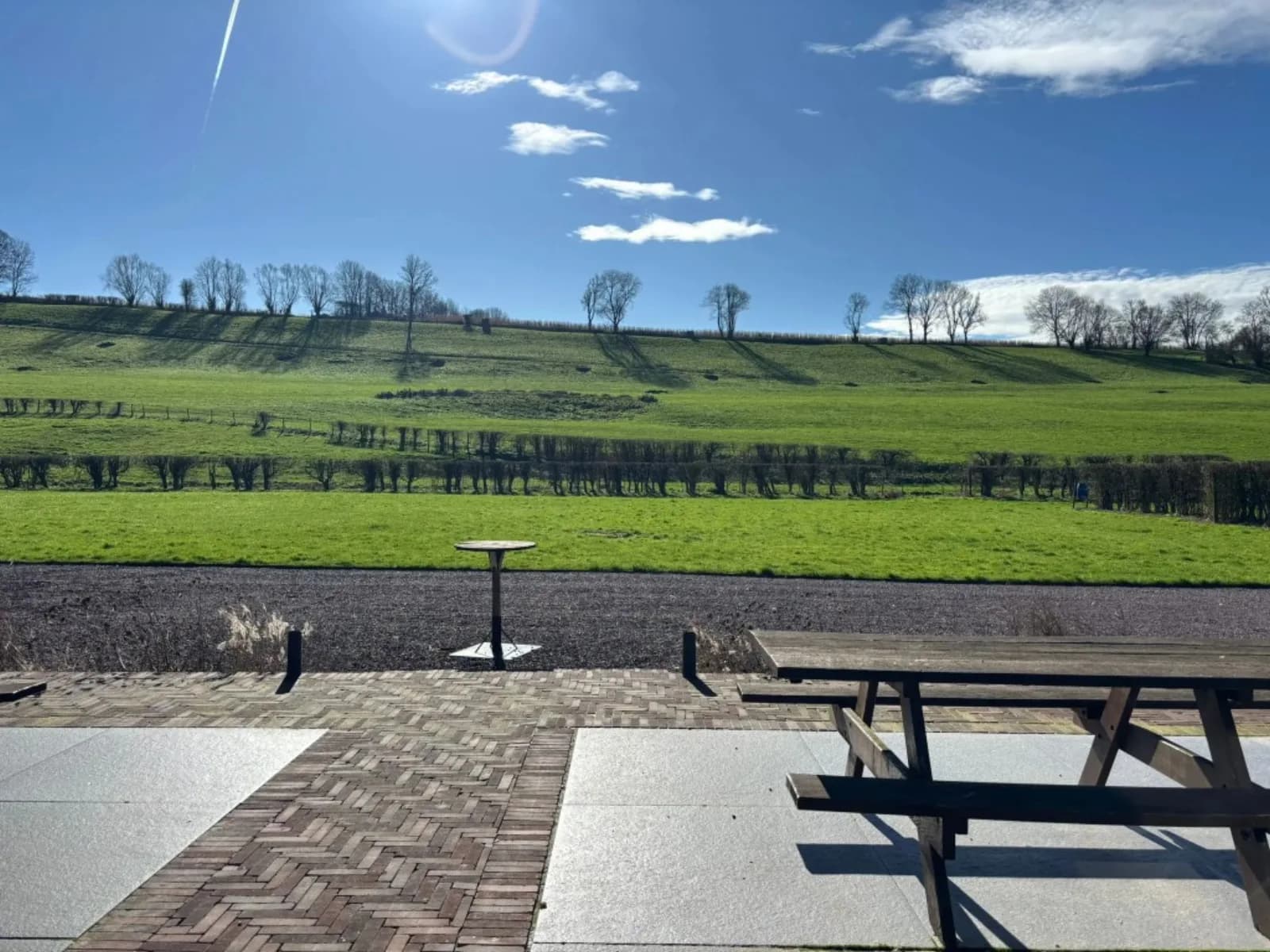 Les extérieurs — terrasse en pierre, tables de pique-nique et vue sur la campagne