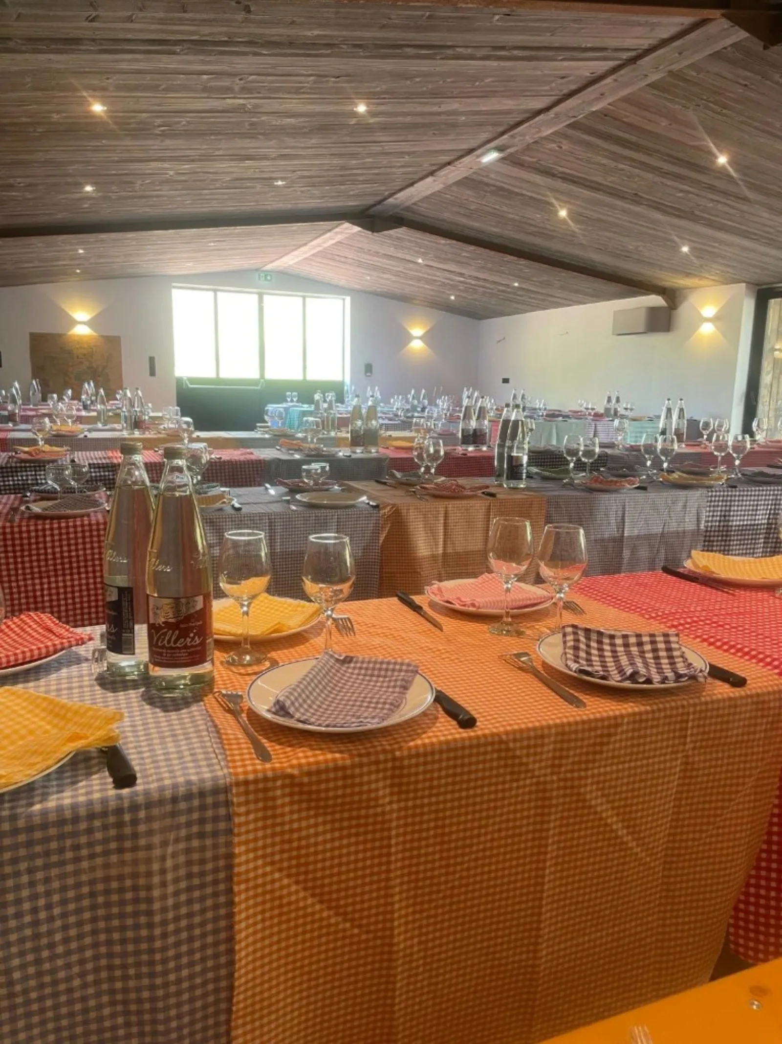 La Grange — salle de réception mariage, tables dressées à carreaux et plafond en bois