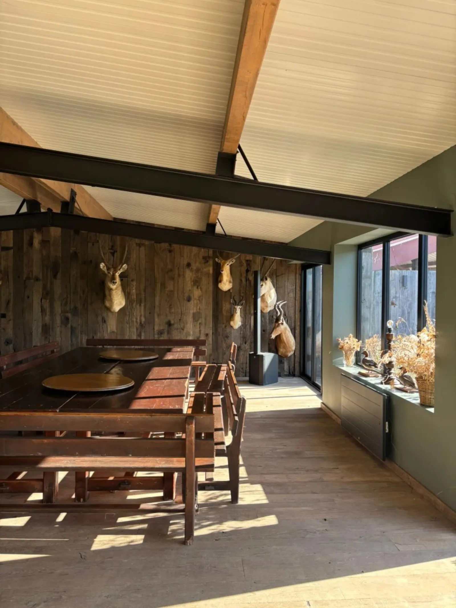 Le Relais — salle de réception, mur en bois ancien et trophées